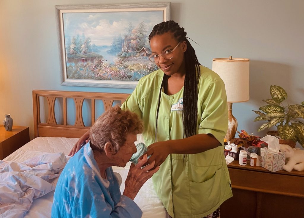 caregiver helping woman drink water