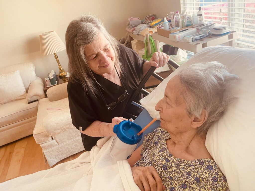 helping older woman take a drink